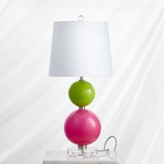 a table lamp with two balls on it and a white lampshade behind it