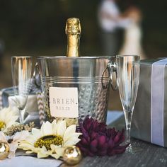 two champagne flutes and some flowers on a table