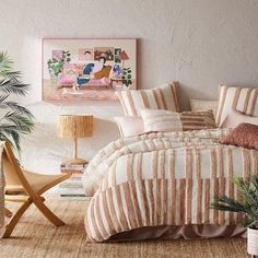 a bedroom with a bed, plant and pictures on the wall