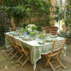 the table is set with green plates and place settings for four people to sit at