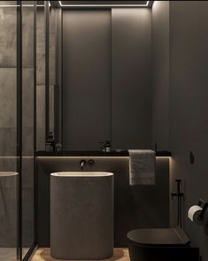 a bathroom with a toilet, sink and shower stall in the corner is lit by recessed lighting