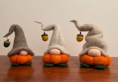 three small stuffed animals sitting on top of each other in the shape of pumpkins