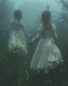 two girls in white dresses are walking through the foggy woods with yellow wildflowers