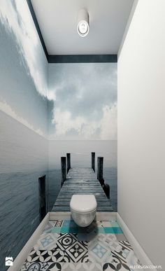 a white toilet sitting in the middle of a bathroom next to a wooden dock on top of water