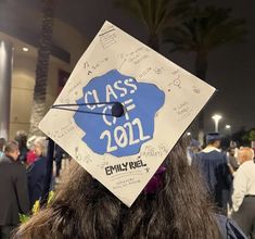 a graduate's cap with writing on it in front of a group of people