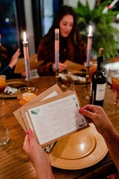 people sitting at a table with wine and menus