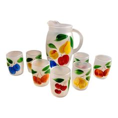 a pitcher and six glasses with fruit painted on them