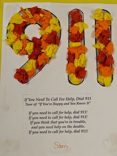 a letter made out of orange and yellow flowers on top of a white paper sheet