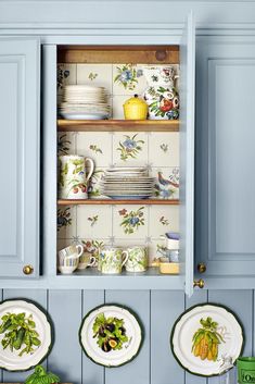 blue cabinets with plates and cups on them