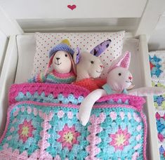 a crocheted bed with stuffed animals on it