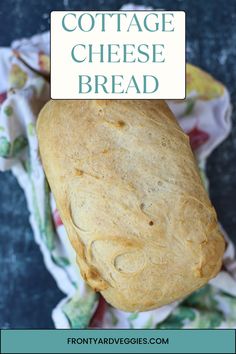 a loaf of cottage cheese bread sitting on top of a cloth covered tablecloth with the words cottage cheese bread