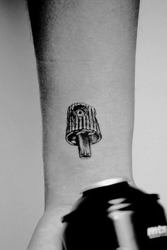 a black and white photo of a person's wrist with a mushroom tattoo on it