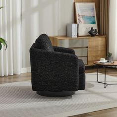 a living room with a black chair and white rug