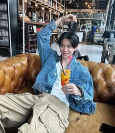 a woman sitting on top of a couch holding a drink