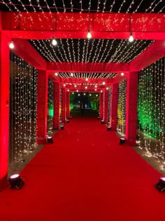 a red carpeted walkway is lit with christmas lights