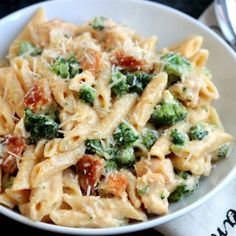 a white bowl filled with pasta and broccoli