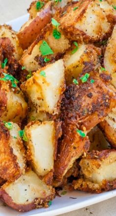 a white plate topped with potatoes covered in seasoning