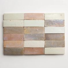 a white wall with several different colored tiles on it