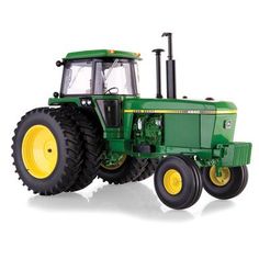 a green tractor with yellow wheels on a white background and no people in the photo