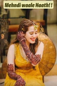 a woman in yellow dress sitting down with her hands on her face and the words mehndi waale hath