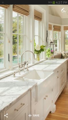 a large kitchen with white cabinets and marble counter tops