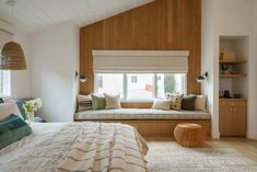 a bed room with a neatly made bed and a large window in the wall next to it