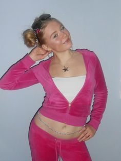 a woman wearing pink pants and a white top is posing for the camera with her hand on her head