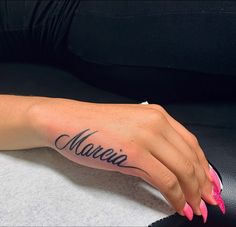 a woman's hand with a name tattoo on it