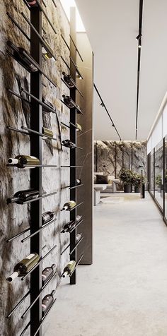 a long hallway with lots of wine bottles on the wall and glass doors leading to another room