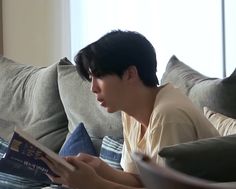 a person sitting on a couch reading a book