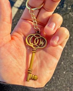 a person holding a golden key with the word monogram on it in their hand