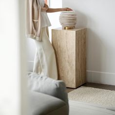 a woman standing next to a lamp in a living room