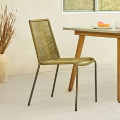 a dining table with two chairs next to it and a bowl of fruit on the table