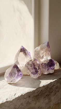 Amethyst crystals on a stone windowsill, reflecting sunlight. Fotorrealism, minimalist aesthetic, soft beige and brown tones, plenty of negative space. NO TEXT INCLUDED. Angel Art, Crystal Grid, Crystal Gems, Crystals And Gemstones, House Decor, Gemstones