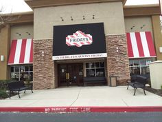 the front entrance of a furniture store with two black chairs in front and red and white striped awnings