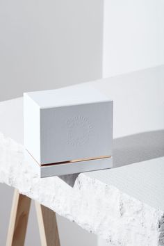 a white box sitting on top of a wooden stand