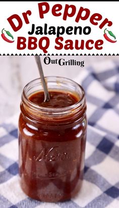 a jar filled with bbq sauce sitting on top of a checkered table cloth