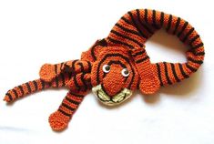 an orange and black stuffed animal laying on top of a white surface