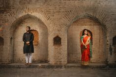 a man and woman standing in an archway