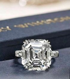 an old cut diamond ring sits on top of a book