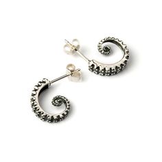 two pairs of silver earrings with spiral design on the front and back ends, one in white