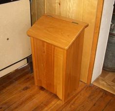 a wooden podium sitting on top of a hard wood floor next to a white refrigerator