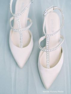 the bride's shoes are all white and have crystal embellishments