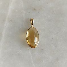 ITEM DESCRIPTION: >> The pendant is made from Solid 14K Yellow Gold. Gemstone used is absolutely natural and ethically sourced. >> Natural Citrine in cabochon Oblong oval shape with bezel setting is studded on it with utmost precision. >> This is a minimalist design and is absolutely hassle-free and everyday jewelry. Gem: Citrine Gem size: 11x19 mm Gem weight: 9.61 carats Gold purity: 14K (58.33% approx.) Gold weight: 0.55 grams Gross weight: 2.47 grams The Gold purity is guaranteed and it comes Yellow Gold Citrine Gemstones For Gift, Oval Citrine Gemstones For Gift, Gold Faceted Gemstone Pendant, Gold Necklace Pendant, Citrine Pendant, Yellow Gold Necklace, Bezel Pendant, Natural Citrine, November Birthstone