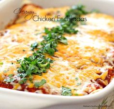 a casserole dish with cheese, meat and parsley in it on a table