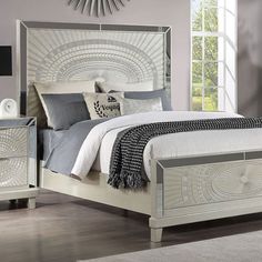 a white bed sitting in a bedroom on top of a hard wood floor next to a window