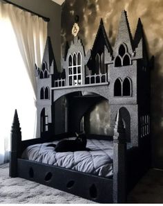 a cat laying on top of a black castle bed