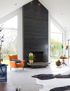 a living room filled with furniture and a fire place in the middle of an open floor plan