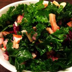 a salad in a white bowl on top of a wooden table