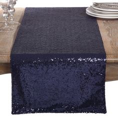 the table is covered with sequins and silverware, along with a black linen runner